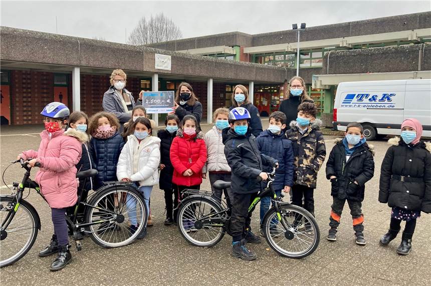 Bezirksbürgermeisterin Hanna Rosenbaum (hinten 2.v.l.) übergab den symbolischen Bildungsscheck für neue Fahrräder an Maren Krebs (hinten l.) vom Förderverein der Diesterweg-Grundschule, Daniela Köchling und Schulleiterin Corinna Holland (hinten r.) und Kinder der Schule.