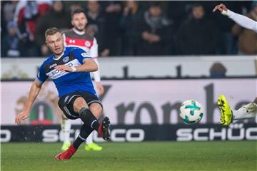 Bielefelds Florian Hartherz (l) erzielt mit seinem Schuss gegen St. Paulis Christopher Avevor (r) das 3:0. Foto: Guido Kirchner