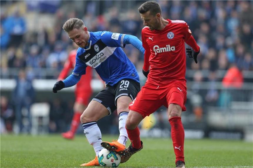 Kiel verpasst Sprung auf Platz zwei - Saibene verlängert Bielefelds Leandro Putaro (l) muss den Ball gegen Kiels Tom Weilandt behaupten. Foto: Friso Gentsch