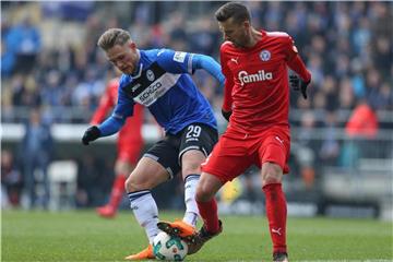 Bielefelds Leandro Putaro (l) muss den Ball gegen Kiels Tom Weilandt behaupten. Foto: Friso Gentsch