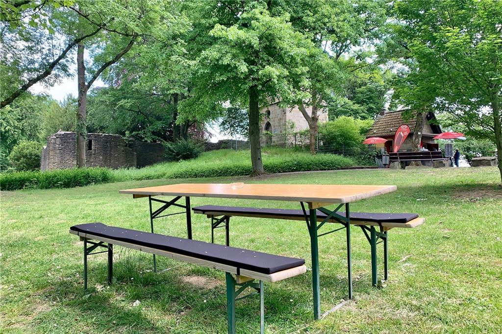 Bierzeltgarnitur im Grünen: Im Hintergrund der Kiosk mit Vincketurm und Burgruine.