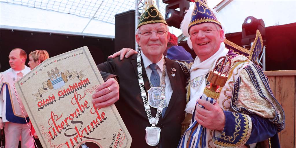 Narren übernehmen trotz Sturm die Macht in Stadtlohn Bürgermeister Helmut Könning (l.) übergab Prinz Manni (r.) neben dem Schlüssel zur Stadt auch eine offizielle Urkunde.