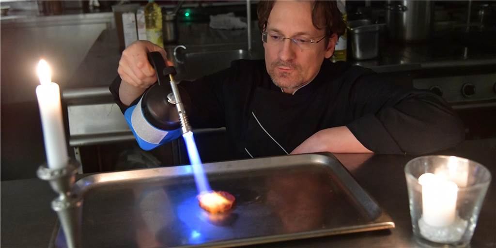 Kochen ohne Strom: Nordkirchener Koch gibt ambitionierte Tipps fürs Kochen im Notfall Was tun, wenn der Strom ausfällt? Die Küche muss auch dann nicht unbedingt kalt bleiben - wenn man einen Gasbrenner hat: Küchenchef Markus Klapper flambiert damit eine dünne Scheibe Rindfleisch.