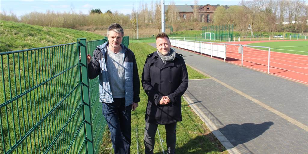 Vereine wollen Sportpark am Bärenbruch in Kirchlinde weiterentwickeln Rainer Buchholz (TSV Kirchlinde, links) und Dr. Jan Wiethoff (DJK Westfalia) an dem Zaun, der verschwinden könnte, wenn der Wall (links) dem Sportplatz zugeschrieben wird.
