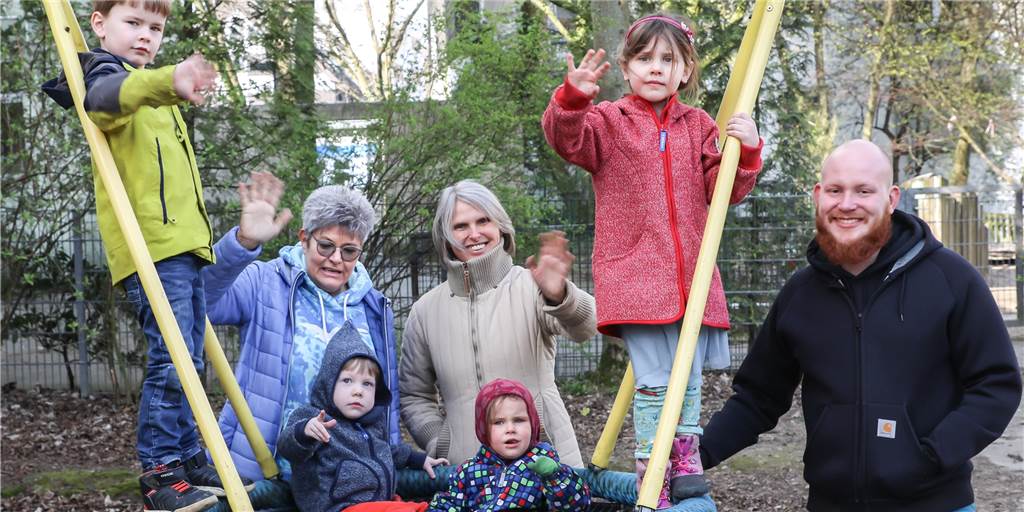 Großer Abstand geht nicht: Kinderbetreuung als echte Herausforderung Das kleine Erzieher-Team um Leiterin Ira Kersebaum (l.) und die Kinder in der Notbetreuung des Nicolai-Kindergartens winken fürs Foto: Der Fotograf musste natürlich außerhalb des Kita-Geländes auf Distanz bleiben.