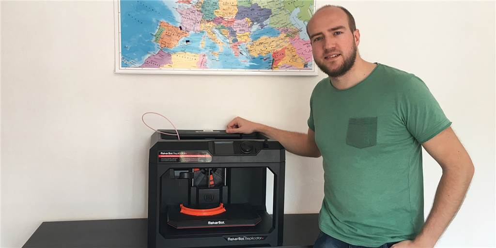 Dennis Menzel betreut den 3D-Druck der Visierhalterungen am Leihgerät des Forschungsnetzwekrs der Ruhr-Universität.