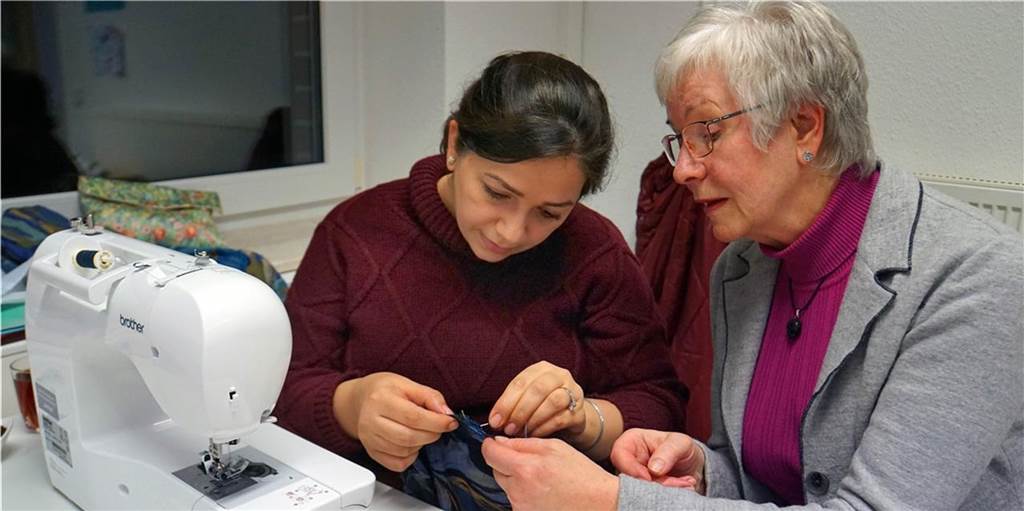 Corona-Krise: Arbeit der Flüchtlingshilfe Ascheberg liegt auf Eis Maria Schumacher, ehrenamtliche Helferin der Flüchtlingshilfe St. Lambertus, hilft einer Iranerin, die sich ein Kleid näht. Solche Nähkurse sind in Zeiten von Corona nicht möglich - genauso wie viele andere Angebote der Flüchtlingshilfe.