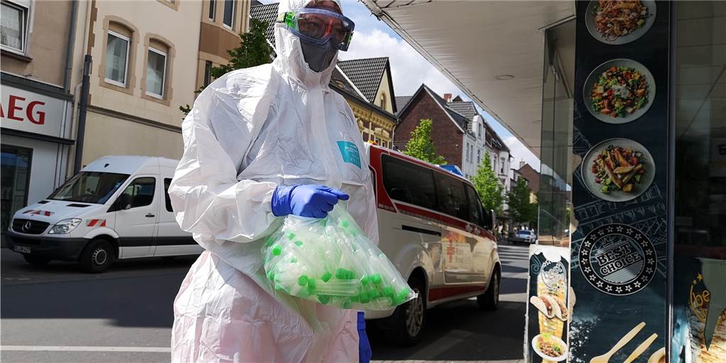 Dem Coronavirus auf der Spur: 200 Castrop-Rauxeler an einem Tag getestet Eine Mitarbeiterin auf dem Weg zum Haus in der Langen Straße, in dem alle Bewohner auf das Coronavirus getestet werden sollen. In ihrer Hand hält sie eine Tüte mit den für den Test notwendigen Röhrchen.