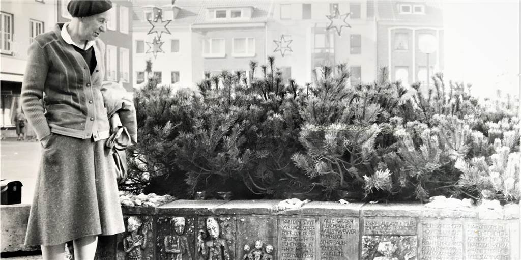 Front gegen Dauer-Abbau des Stadtbrunnens auf dem Marktplatz wächst Künstlerin Tisa von der Schulenburg vor dem im Winter begrünten Marktplatz-Brunnen, deren Reliefarbeiten sie entworfen hat (Datum der Foto-Aufnahme unbekannt).