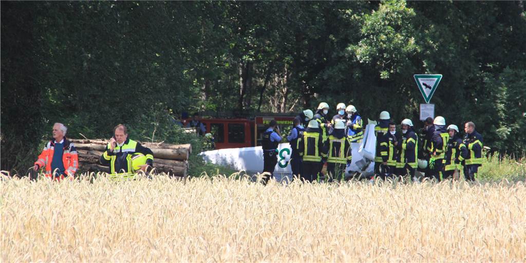 Zwei Segelflieger verunglückt: Anwohner sahen Trümmer vom Himmel fallen Zahlreiche Rettungskräfte waren vor Ort. Ein Wrack lag auf einer Holzbrücke, die über den Mühlenbach führt.
