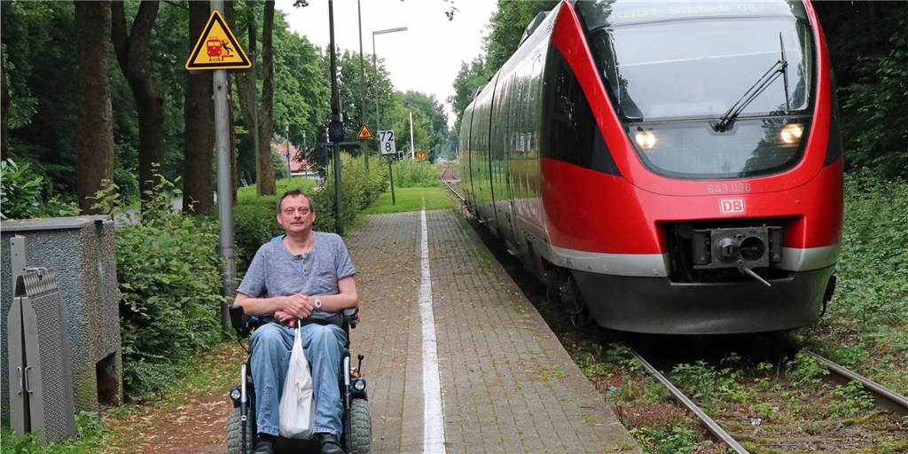 Rollstuhlfahrer stehen gelassen – Bahnpersonal darf nicht helfen Michael Gruhl auf dem Bahnsteig in Legden. Neben ihm ist die Rampe zu sehen, die das Bahn-Personal aufbauen könnte, damit der mit seinem Elektro-Rollstuhl die Kante zwischen Bahnsteig und Zug überwinden kann. Die meisten, die ihm helfen, nehmen aber die Rampe aus der Bahn selbst. Nur: Auch das sollten sie nicht.