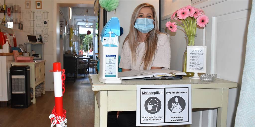 „Selbst wenn wir einen Monat schließen müssen, ist das existenzgefährdend“ Mitarbeiterin Maggy Rozwadowski (26) begrüßt die Gäste im Café Oma Rosa und weist auf das Corona-Hygienekonzept hin.