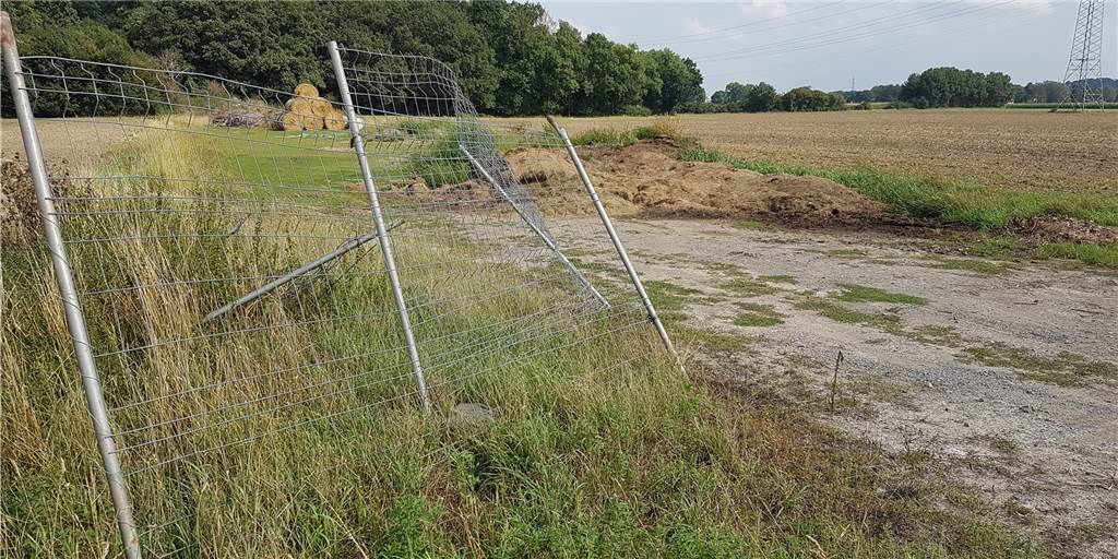 Illegale Müllkippe: EDG kann nichts gegen Abfall auf diesem Feld tun Der zur Hälfte umgestürzte Zaun und die illegale Müllablagerung am Ostenschleifweg in Dortmund bergen Gefahren für Mensch und Tier.