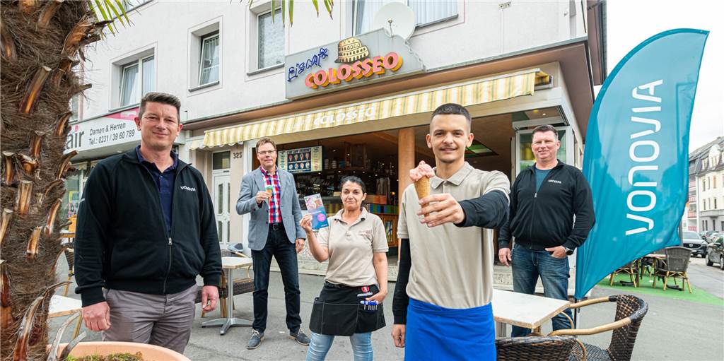 Modernisierungs-Offensive: Vonovia frischt knapp 500 Wohnungen auf Die Vonovia Mitarbeiter Patrick Klip (links), Volker Hehle (2.v.l.) und Peter Sosniak (rechts) haben das kleine Dankeschön für die Mieter beim Eiscafé Colosseo organisiert.