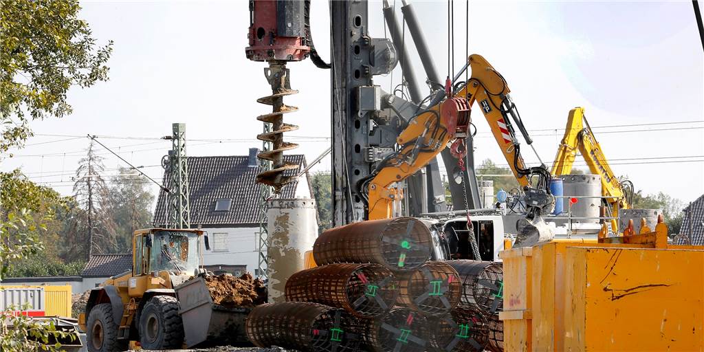 Große Baumaschinen, Tiefbohrgeräte und stählerne Röhren, die den Betonpfählen Halt geben. Auf der Baustelle für die Eisenbahnüberführung der Südkamener Spange laufen die Arbeiten für das 300 Meter lange Trogbauwerk.  
