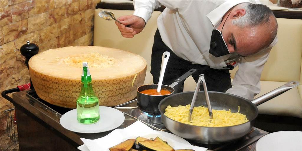 Flammen aus dem Käse-Vulkan machen Pasta zum Geschmackserlebnis Aus Berlin hat Koch Domenico die Kunst mitgebracht, seine Pasta in dem geschmolzenen Käselaib zuzubereiten.