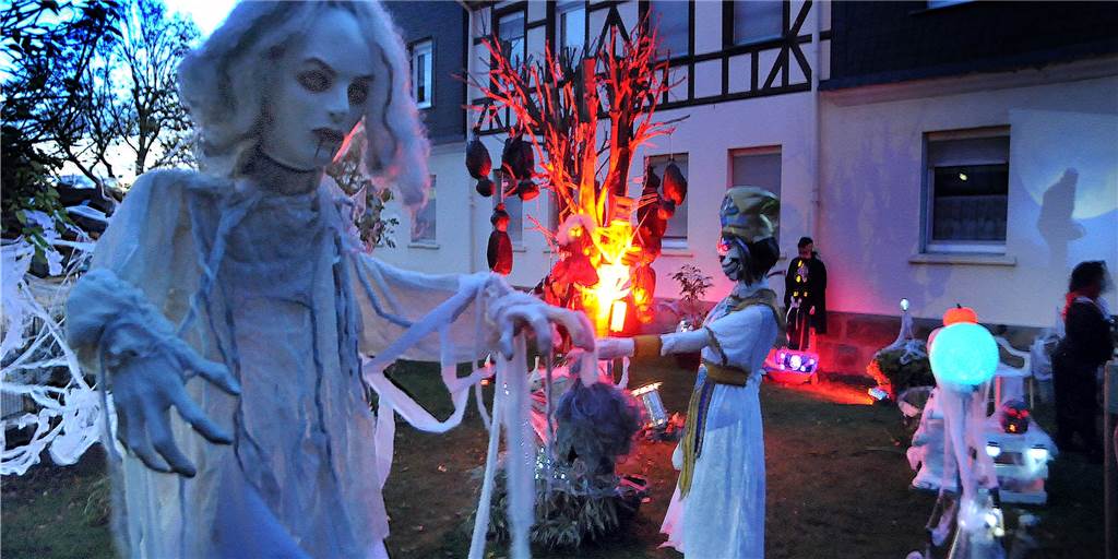 Am „Horrorhaus von Geisecke“ tanzten Vampire und Knochenmänner Im Vorgarten tanzen die Vampire unter dem Baum mit den Leichsäcken, während der Beamer den Kettensägenmann an die Hausfassade wirft.