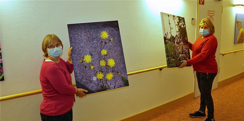 Alltagsbegleiterin Elke Luhmann-Finke (l.) und Hausleiterin Nicole Fischer zeigen die neuen Bilder und Fotos in den Fluren des Malteserstifts.
