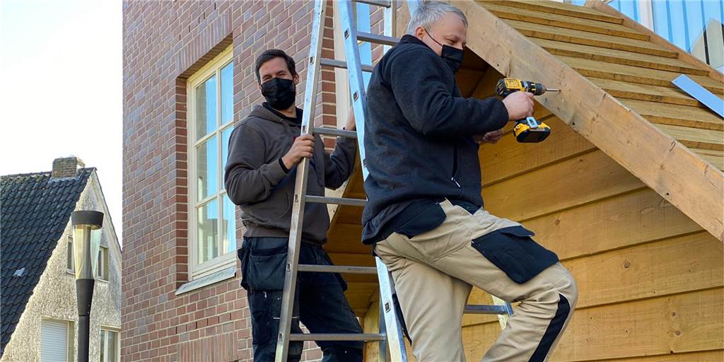 Corona-Regeln für das Handwerk: Masken im Bulli und getrennte Pausen Michael Räwer (l.) und Michael Wüpping von "Dieker Objekteinrichtung" haben in den vergangenen Tagen die Holzverkleidungen an den Geschäften angebracht. Das tragen einer Mund-Nasen-Bedeckung gehört für sie schon zur Routine.