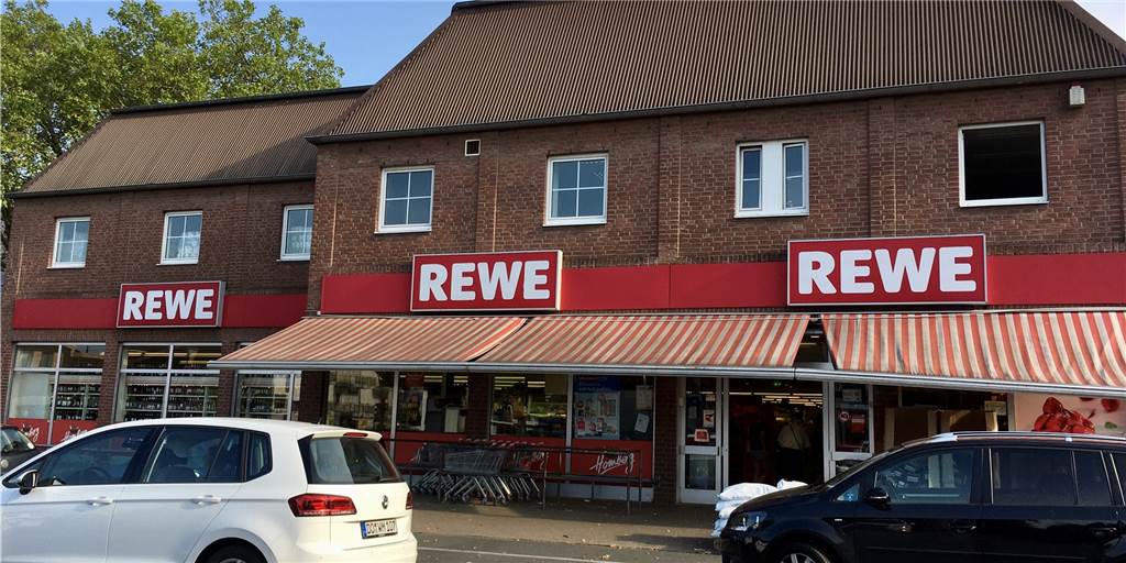 Betrüger wollen Opfer mit Armani-Masche am Rewe-Parkplatz abziehen Auf dem Parkplatz hinter dem Rewe an der Overgünne lauerten die Betrüger.