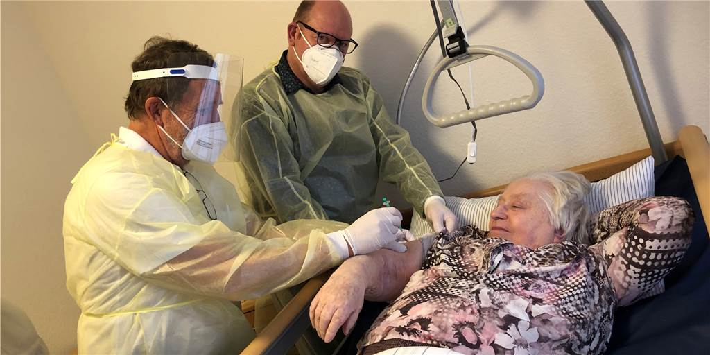 Impfstart im Kreis Borken: 96-jährige Luise Weymann war ältester Impfling Dr. Stephan Gutermann (links) impfte am Sonntag (27. Dezember) die ersten 50 Seniorinnen und Senioren sowie fünf Mitarbeiter des Senioren- und Pflegezentrums St. Ludger. Im Bild der älteste Impfling Luise Weymann (96) und Wohnbereichsleiter Norbert Schöpe (Mitte).