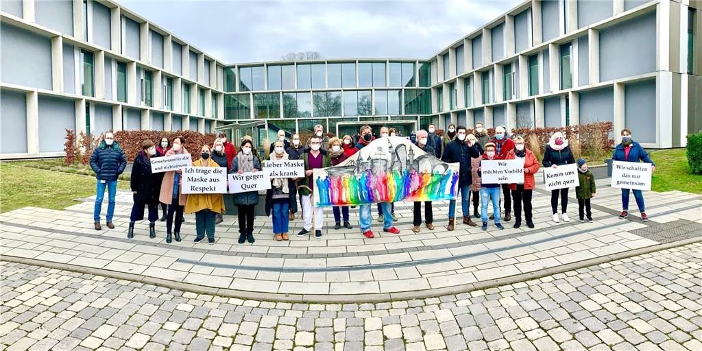 Querdenkern die Maske vors Gesicht halten: LWL-Klinik unterstützt Aktion Mitarbeiterinnen und Mitarbeiter der LWL-Klinik posieren mit der riesigen Maske vor dem Phoenix-Haus auf dem Klinikgelände.