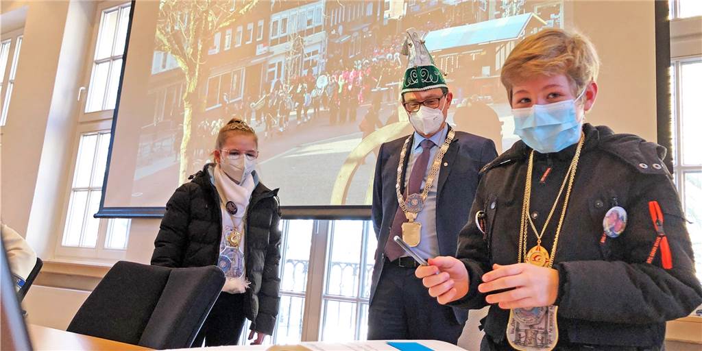 Altweiber in Stadtlohn: De-un-Da wird im Coronajahr nur geflüstert Schülerprinzessin Nelia und Schülerprinz Florian tragen sich unter den Augen von Bürgermeister Berthold Dittman in das Goldene Buch der Stadt ein.