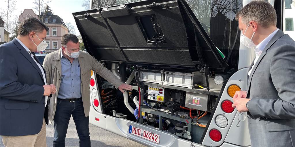Warum ein Wasserstoffbus mit dem Motor der Wirtschaft fährt Manfred Gerster von der Herstellerfirma Van Hool erklärt Landrat Mario Löhr (l.) und Kreisdirektor Mike-Sebastian Janke, was der Wasserstoffbus unter der Haube hat. Ein Motor ist auf den ersten Blick nicht zu sehen, weil die Technik der Brennstoffzelle am meisten Raum einnimmt.