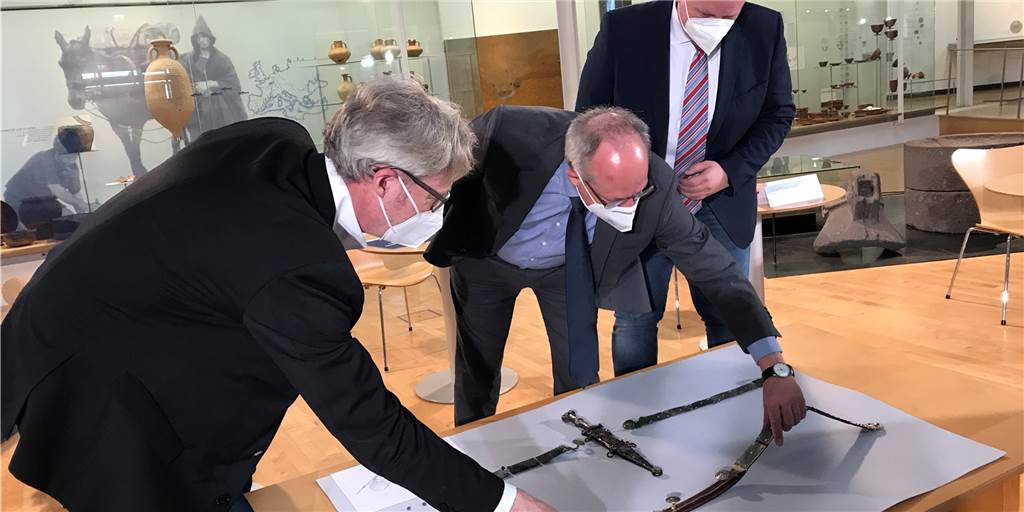 Mit Video: LWL-Römermuseum in Haltern baut Wachhaus mit Escape Room LWL-Römermuseums-Direktor Dr. Josef Mühlenbrock (v.l.), LWL-Direktor Matthias Löb und Halterns Bürgermeister Andreas Stegemann vor dem antiken Dolch.