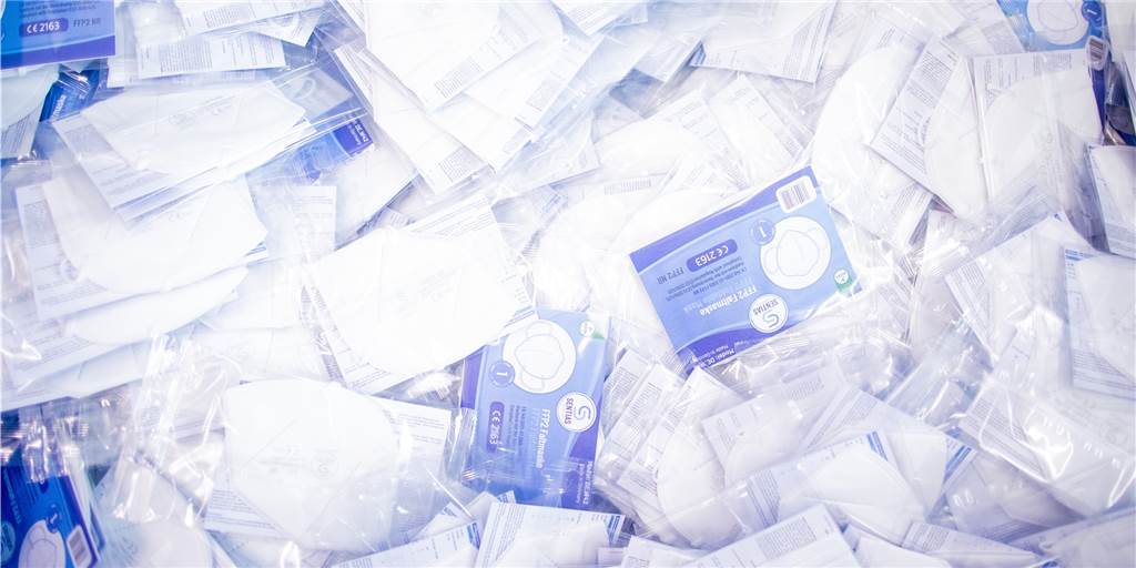 Tafel-Ausgabestelle in Lünen: Maskenverteilung ohne Beschwerden Das Bild zeigt fertig verpackte FFP2-Schutzmasken in einer Tonne in einer Produktionsstätte.