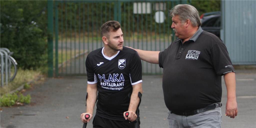 Ein Symbolbild für seine Zeit bei Eintracht Werne: Steven Farchmin auf Krücken mit dem Sportlichen Leiter Rainer Fiebig.