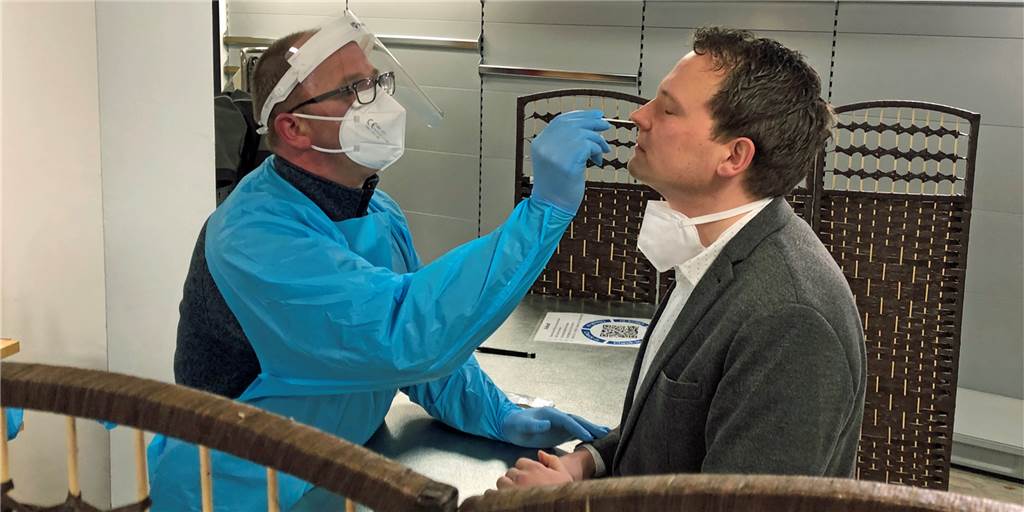 Testen statt Zapfen: Vredener Gastwirt hat wegen Corona umgesattelt Gastwirt Thomas Ostendarp in der Teststation im Einsatz: Er nimmt einen Abstrich bei Bürgermeister Tom Tenostendarp.