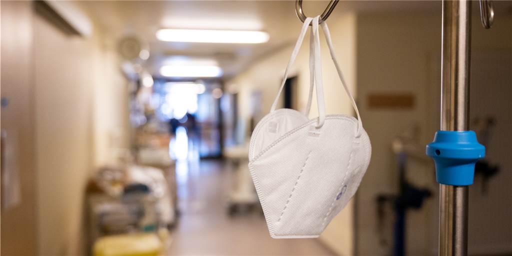 Corona-Tote: Zwei Experten schätzen die Lage in Dortmund ein In einem Flur einer Intensivstation, in der Corona-Patienten mit schweren Krankheitsverläufen behandelt werden, hängt eine Mund-Nasen-Schutz Maske.