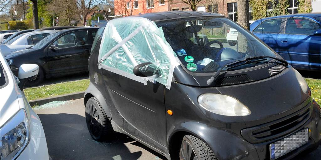 Autoknacker (15) nach 22 Uhr erwischt: Jetzt droht ihm noch Corona-Bußgeld Notdürftig mit Plastikfolie geflickt wurde die eingeschlagene Seitenscheibe dieses Kleinwagens auf dem Parkplatz Im Reiche des Wassers. Im seinem Innenraum und auf dem Asphalt waren überall Splitter vom Sicherheitsglas verstreut.