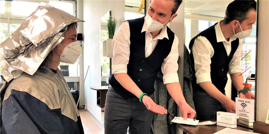 Neue Corona-Teststelle: Erster Dortmunder Friseur hat die Lizenz zum Testen David Ehwein, Inhaber von Coiffeur Thadeusz, ist Dortmunds erster Friseur mit einer eigenen Corona-Schnelltest-Station. Hier zeigt er der Kundin seine Test-Auswahl.