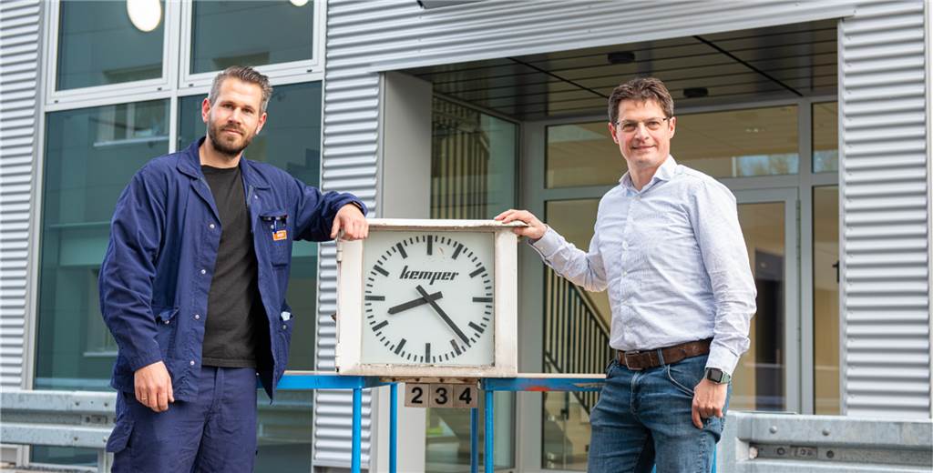 Neue Verwaltung: Maschinenfabrik Kemper reißt alte Gebäude am Breul ab Die Kemper-Mitarbeiter Marcel Nordkamp und Cliff Kalmbach freuen sich darüber, dass die "historische" Werksuhr ihren Platz in dem neuen Verwaltungsgebäude findet.