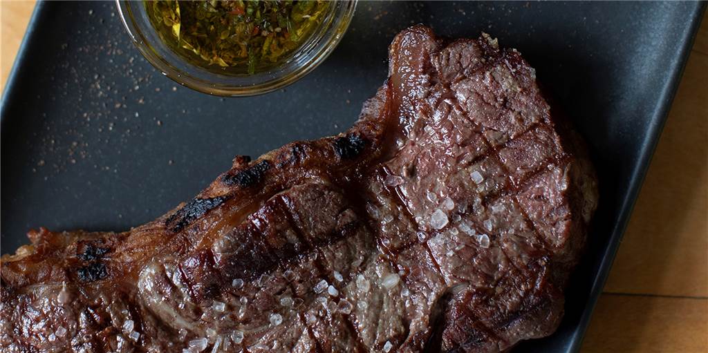 Ein dynamisches Duo. Gegrilltes Rindfleisch und die harmonierende Sauce namens "Chimichurri, 