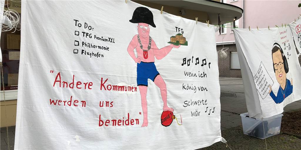 Entrückter Sonnenkönig gegen kleine Bürger? Bleibt doch einfach bei der Sache! Hier ein Banner von der Demo am 5. Mai. Sie zeigt Bürgermeister Dimitrios Axourgos als Napoleon.