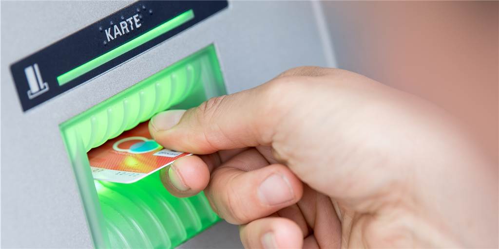 Eine Bankkundin steckt ihre Girokarte in einen Geldautomaten. Doch gerade  für Menschen im Rollstuhl sind die heutigen Überweisungsterminals schlicht zu hoch. Sie werden offenbar nicht mehr hergestellt.