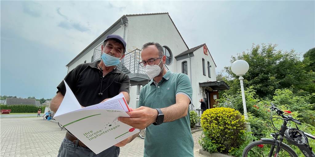 Dortmunder Moscheen wurden zu Impfzentren: „Gott hat mich geschickt“ Emre Gülec (r.), Vorsitzender der Ditib-Moschee-Gemeinde in Huckarde, schaut mit Halit Calik (52) aus dem Stadtteil in die Impf-Broschüre: Calik holte sich am Samstag seine Zweitimpfung mit dem Biontech-Impfstoff ab, nachdem ein Arzt in Witten ihm vor Wochen die erste Spritze verabreicht hatte.