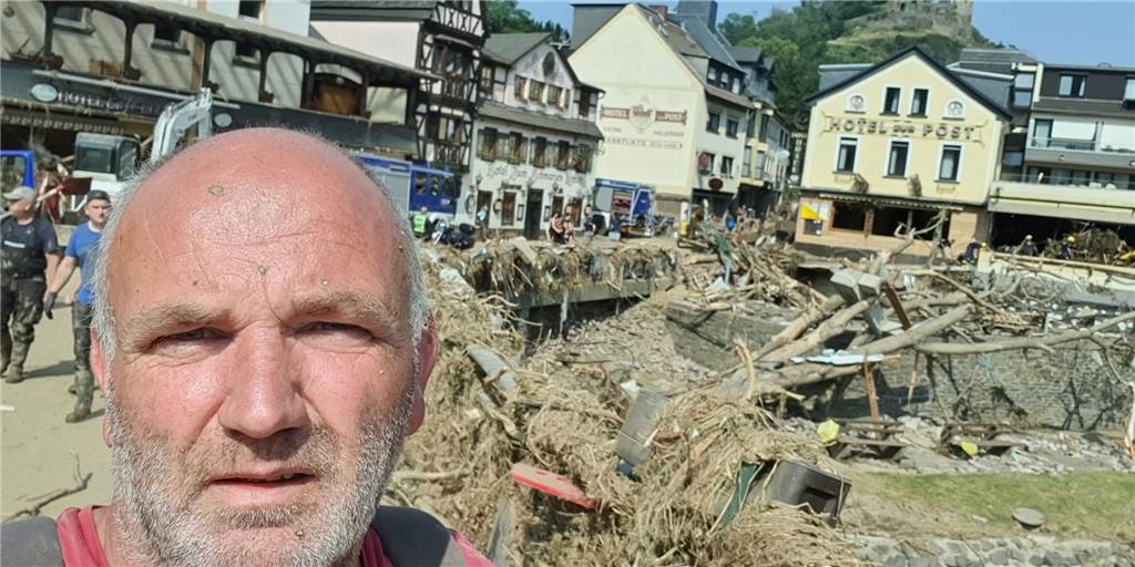Berthold Kortbus vor einem völlig zerstörten Ortskern im Hochwasser-Katastrophen-Gebiet.
