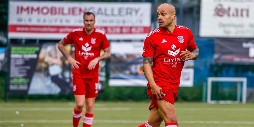Während alle Spieler feiern oder dem Trainer zuhören, treibt Odonkor in der Kabine Sport Während alle Spieler feiern oder dem Trainer zuhören, treibt Odonkor in der Kabine Sport
