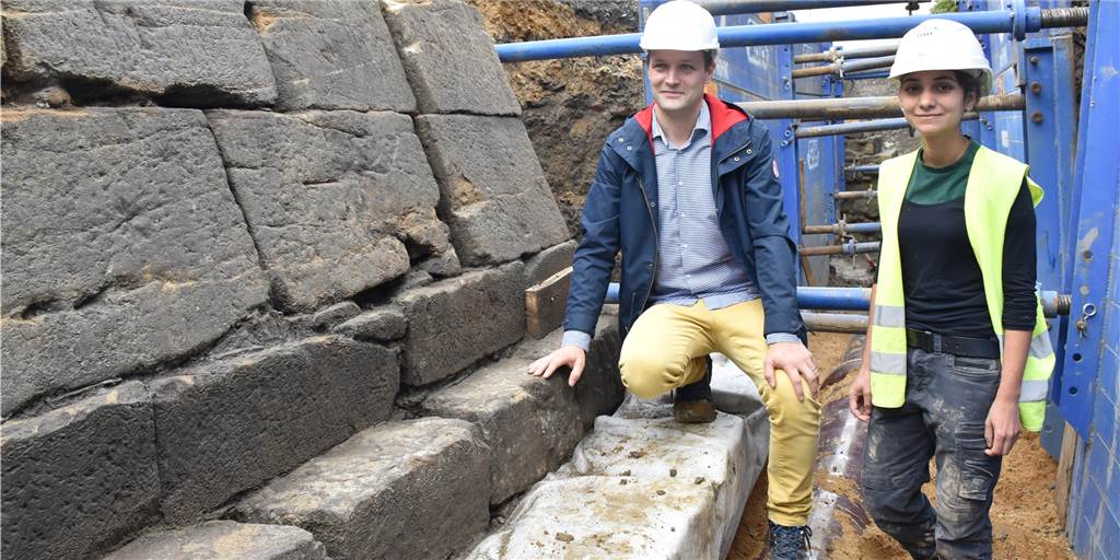 Archäologe zu historischem Fund am Wall: „Für uns völlig neu“ Stadtarchäologe Ingmar Luther und Grabungsleiterin Noelia Madrigal stehen neben einem Strebpfeiler der historischen Stadtmauer.
