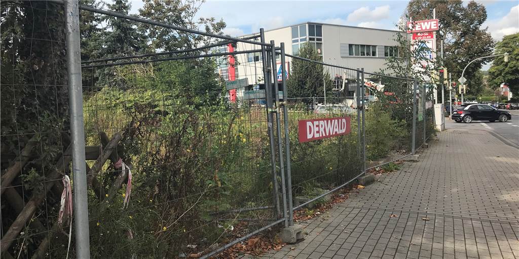22 Wohnungen entstehen mitten im Ortskern – eine im Penthouse-Stil Hoch schon steht das Gras auf dem unbebauten Grundstück an der Einfahrt zu einem Einkaufszentrum. Doch das wird sich spätestens kommendes Jahr ändern.