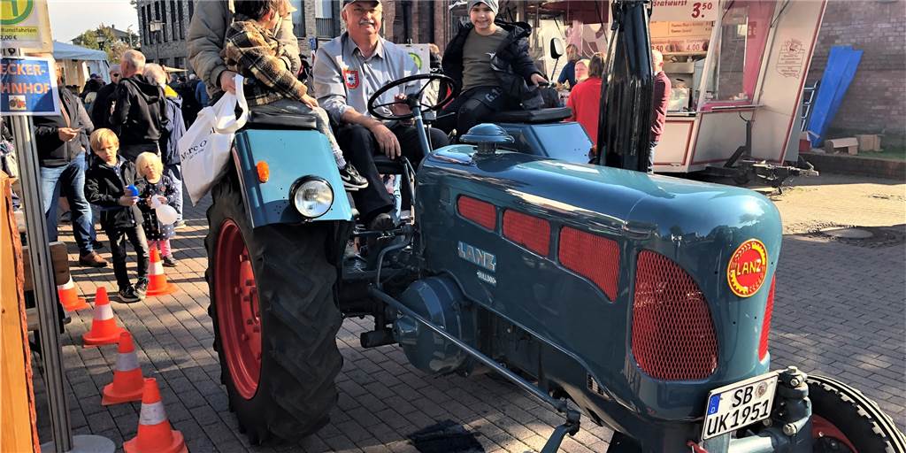 Herbstfest profitiert vom schönen Wetter: „Die Stadt lebt“ Ulrich Keller von den Oldtimerfreunden Lembeck drehte mit den jungen Besuchern des Herbstfests einige Runden auf seinem Lanz Bulldog.