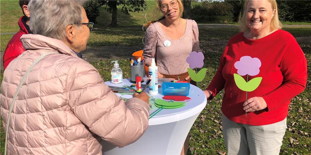 Seelische Gesundheit: Abstand sollte nicht zur inneren Haltung werden Antje Leisten und Katharina Bauer (v.r.) ermutigten die Besucher, ihre Wünsche an der Wunschwiese aufzuschreiben und auf Papp-Blumen einzupflanzen.