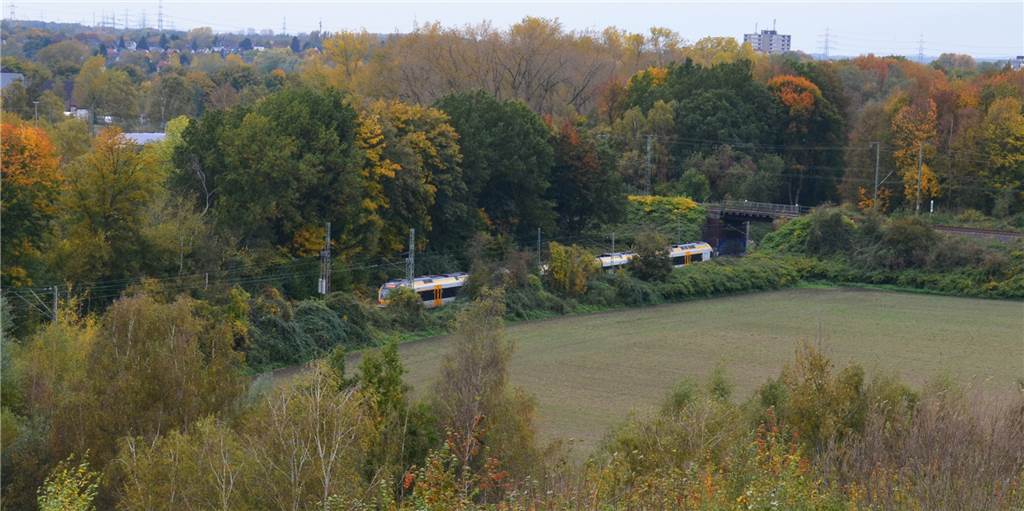 Halten Regionalzüge im Dortmunder Westen bald an einer neuen Station? Unterhalb des Deusenbergs und am Nahverkehrsmuseum Mooskamp (oben links) vorbei verläuft die Bahnstrecke der Köln-Mindener-Eisenbahnlinie. An dieser Stelle könnte etwa die RB 32 (im Bild) künftig halten, fordern Politiker.