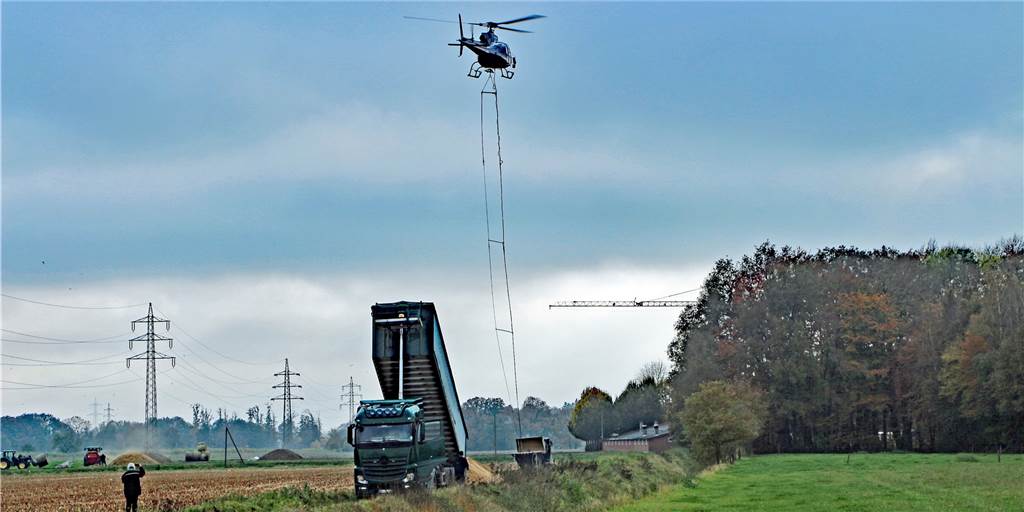 Echte Präzisionsarbeit leisten Luft- und Bodencrew bei einer Waldkalkung. Per Radlader wird der Streubehälter am Boden befüllt, bevor der Pilot in 25 Metern Höhe wieder abdreht zur nächsten Runde.
