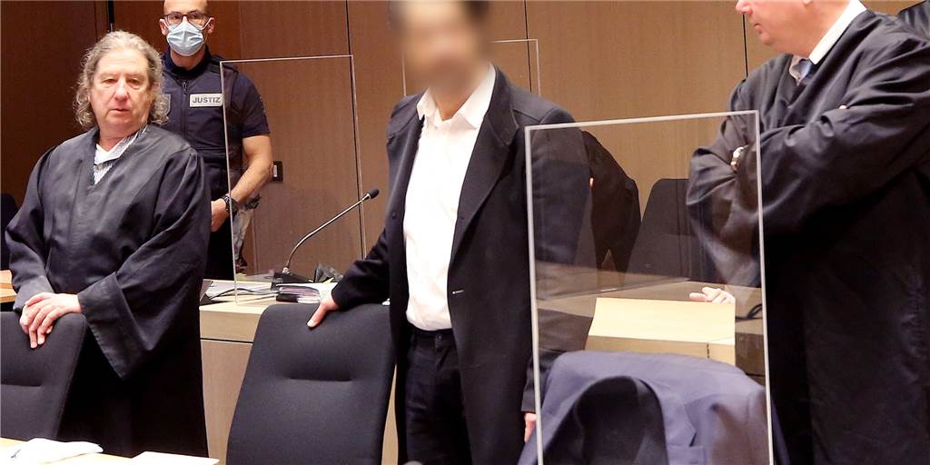 Bochumer wegen Millionen-Betrug mit Medican-Teststellen angeklagt: Dritter Verdächtiger in Türkei? Einer der beiden Angeklagten steht mit seinen Verteidigern im Bochumer Landgericht.