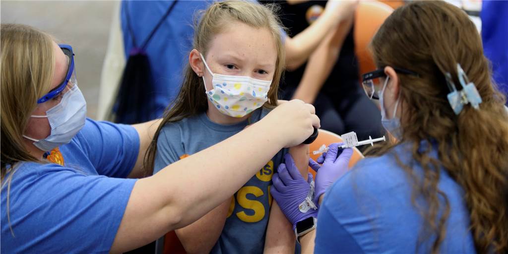 Keine Impfungen von Kindern? Das ist gefährlich Marin Ackerman (M, 10 Jahre alt) erhält eine COVID-19-Impfung von Pfizer von der Krankenschwester Sydney Mogul (r) mit etwas Ablenkungshilfe von der Kinderärztin Hanna Mathess in der ersten COVID-19-Impfklinik in Franklin County für Kinder im Alter von 5-11 Jahren im Nationwide Children's Hospital. (Symboldbild)